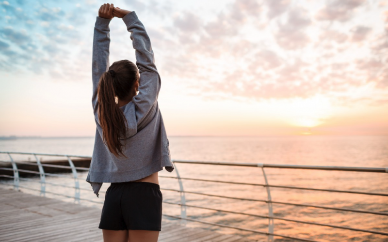 Mujer estirando atardecer